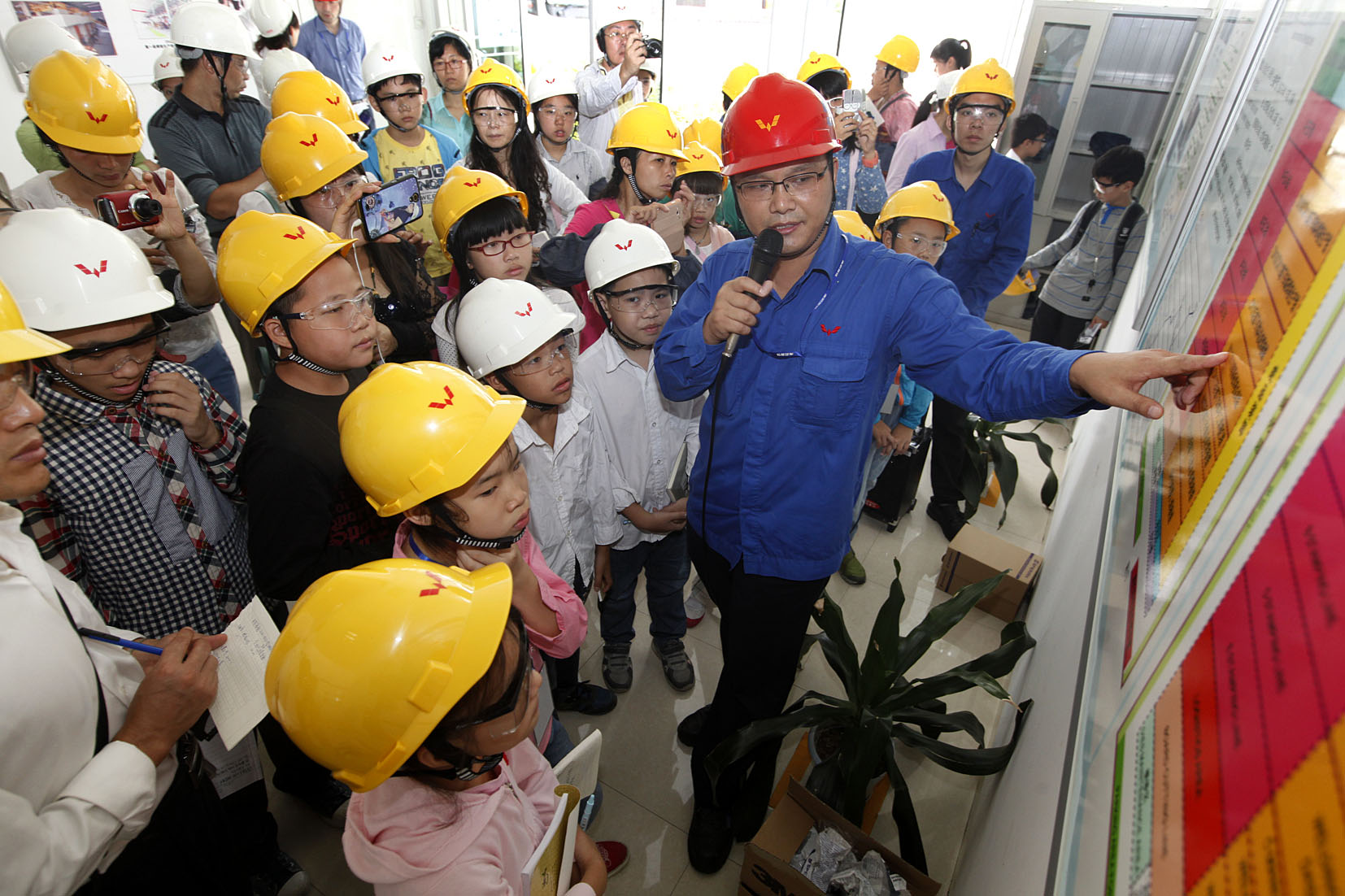 东升国际官网员工向幼记者们介绍冲焊件厂发展情况